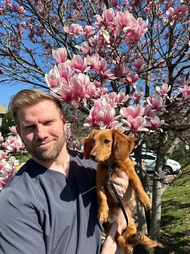 Dr. Jason R. Brown, D.C., outdoors with his dog